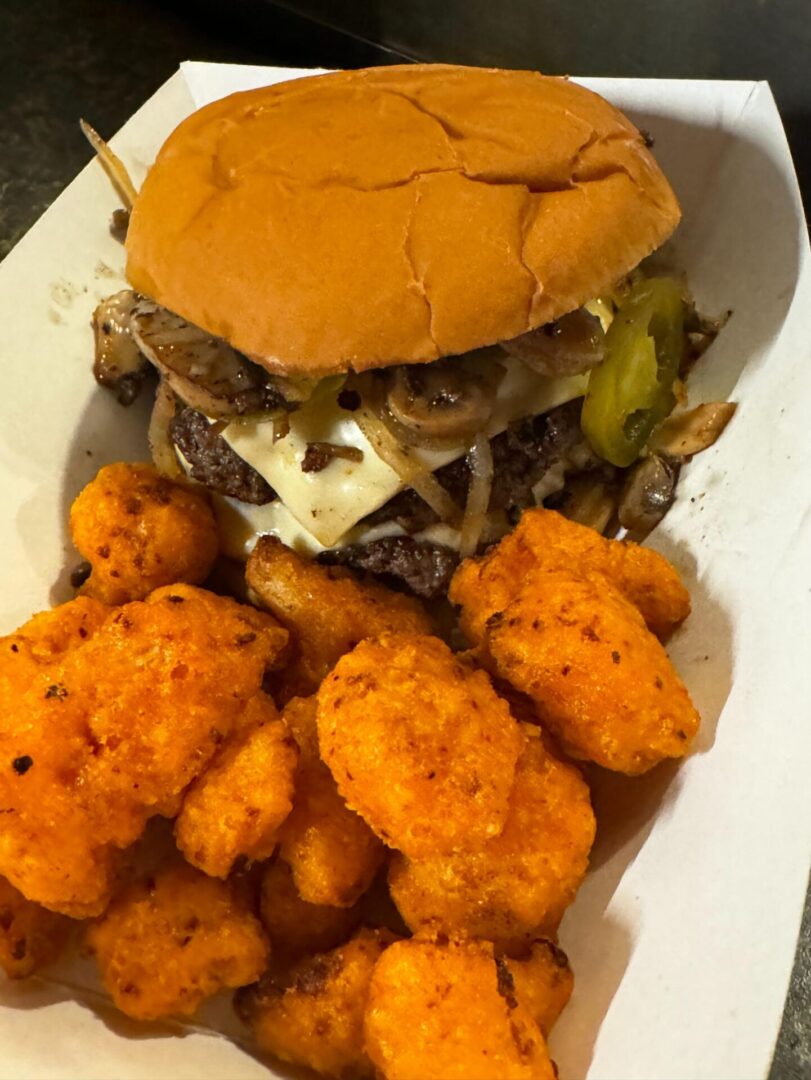 A burger and some fried food on a plate.