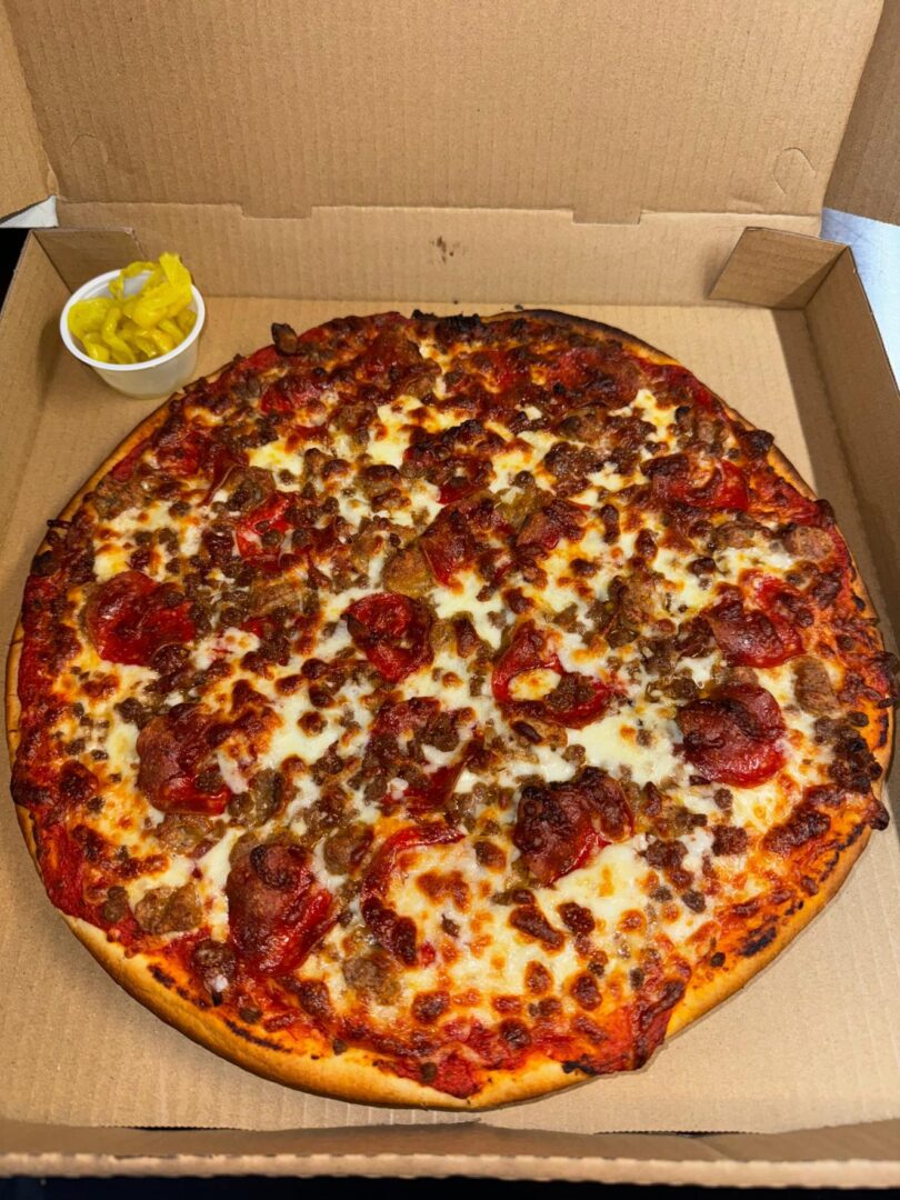 A pizza sitting on top of a box next to a bowl.