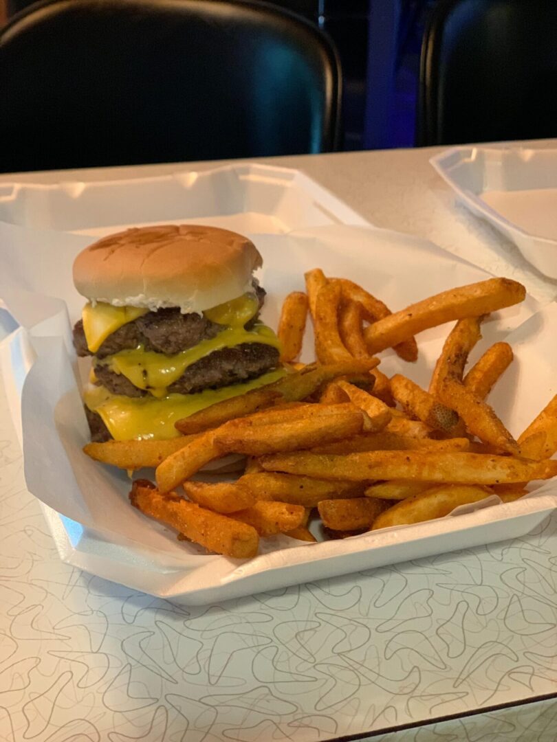 A hamburger and fries are on the table.